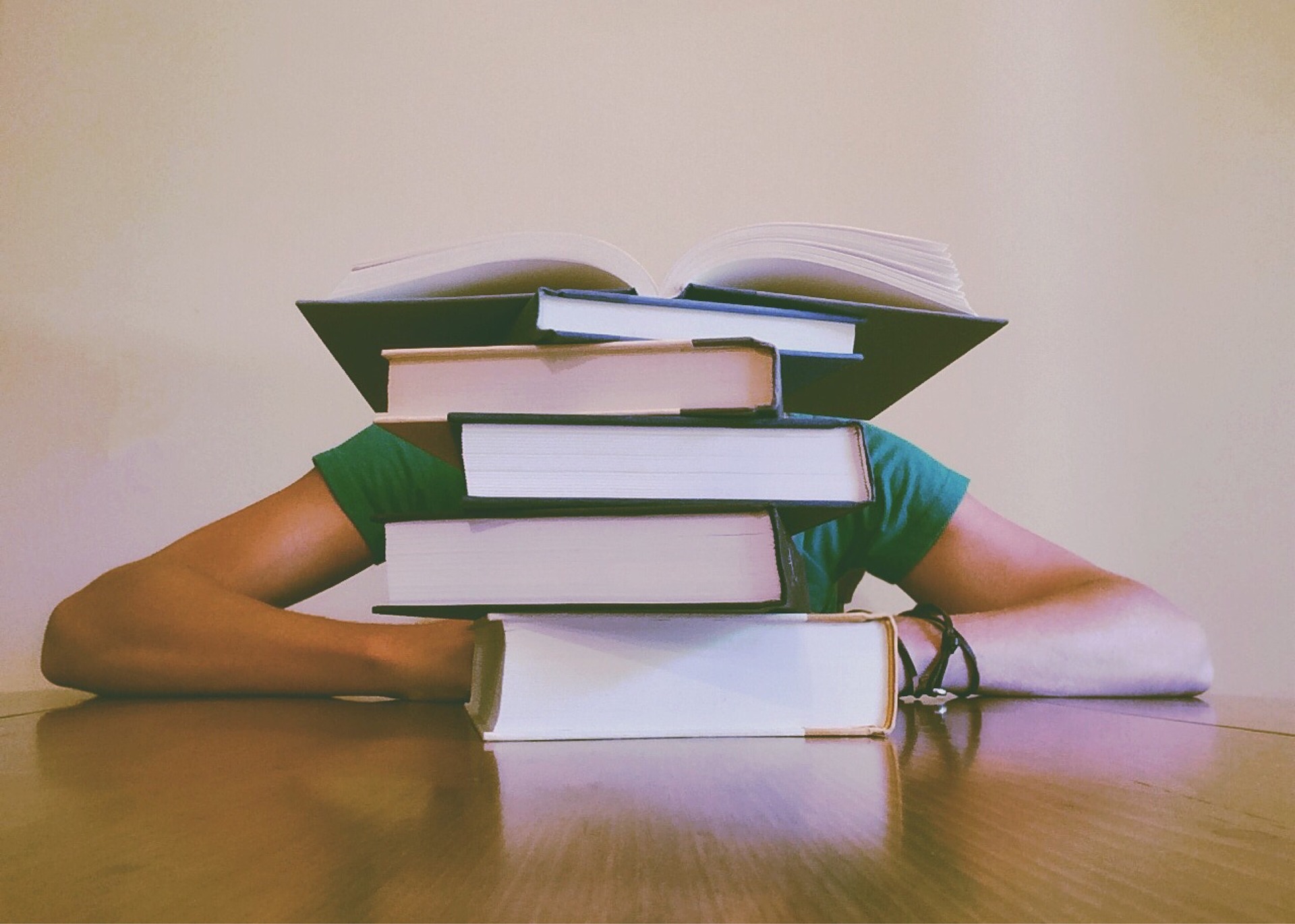 Student behind a pile of books